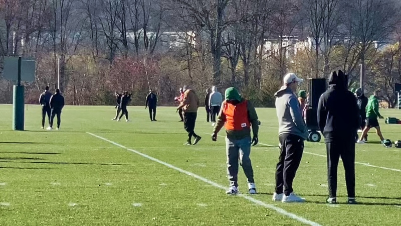 Aaron Rodgers with New York Jets players and staffers at practice,