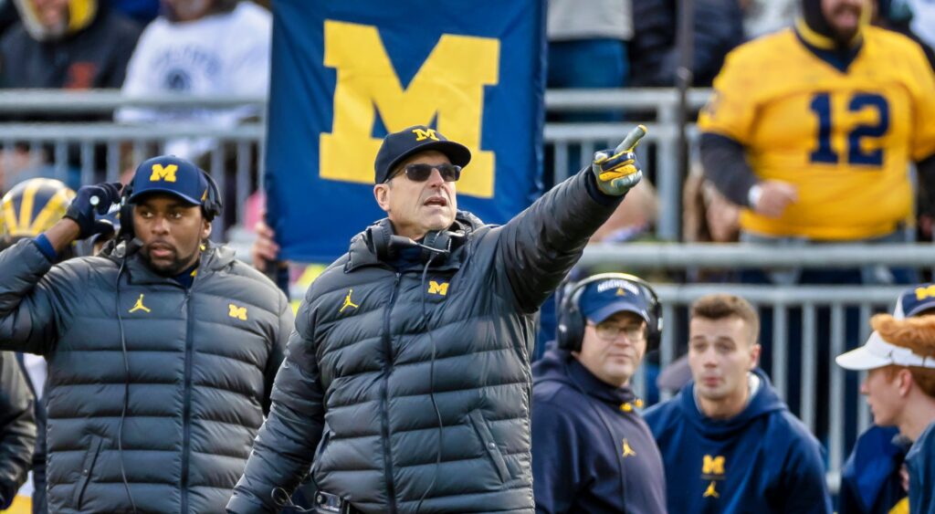Jim Harbaugh points on the sideline.