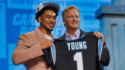 Bryce Yong holding up his jersey with Roger Goodell