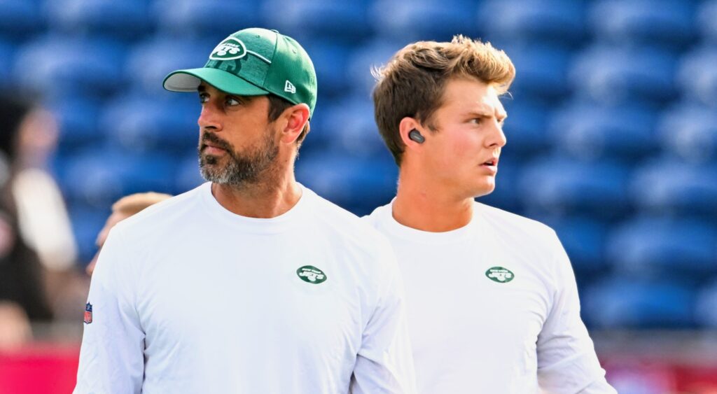 Aaron Rodgers (left) looking on with Zach Wilson (right).