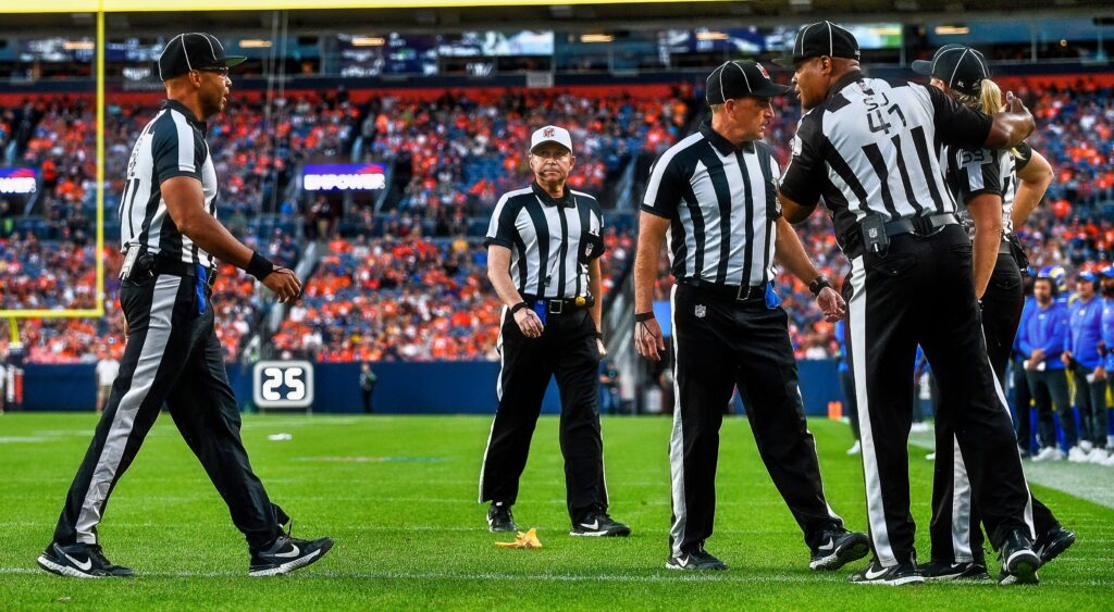 NFL referees meeting on field.