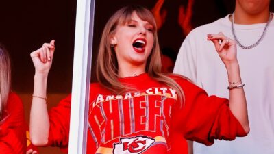 Taylor Swift in suite rocking a chiefs sweater