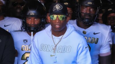 Deion Sanders standing in front of Colorado players