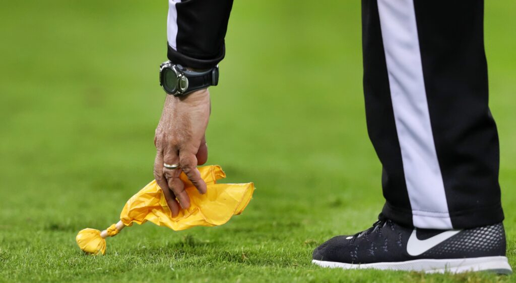 Referee picks up his flag.
