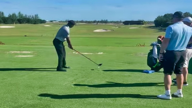 Tiger Woods swinging a club during practice.