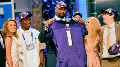Michael Oher holding Ravens jersey near the Tuohy family