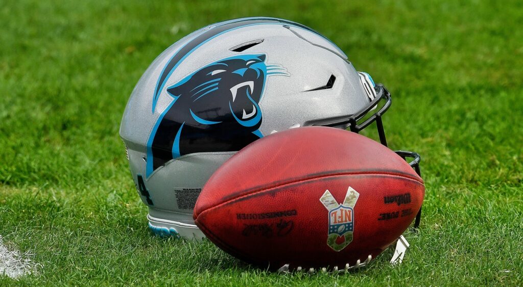 Carolina Panthers helmet and football shown on ground.