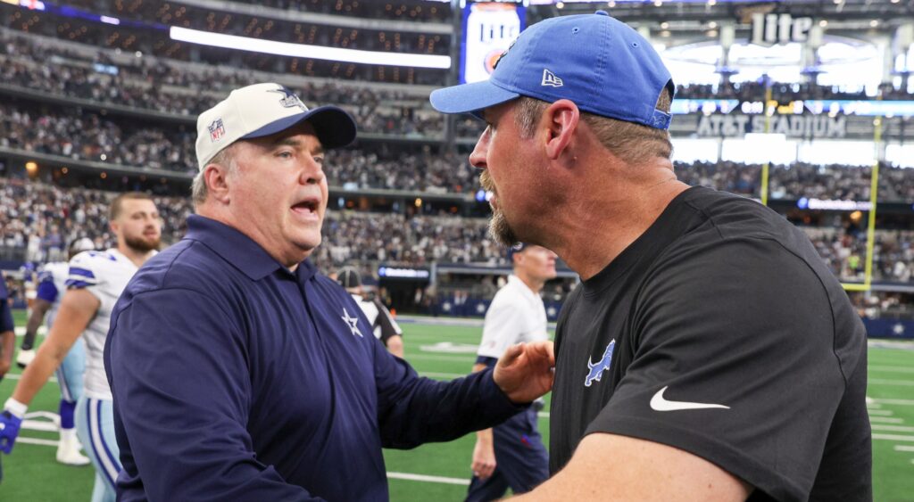 Mike McCarthy (left) meets with Dan Campbell (right) after game.