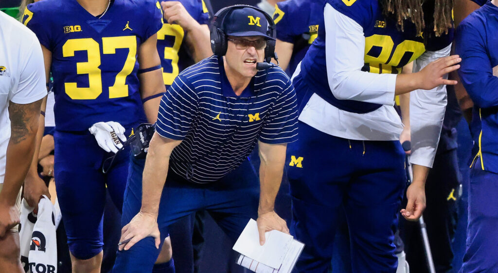 Jim Harbaugh with his hands on his knees