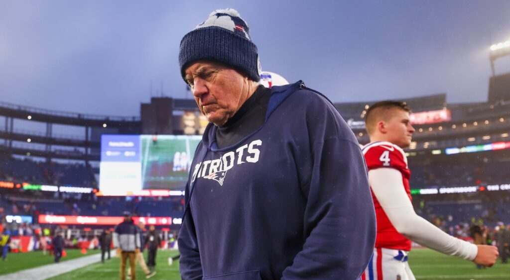 New England Patriots head coach Bill Belichick looking down while walking off field.
