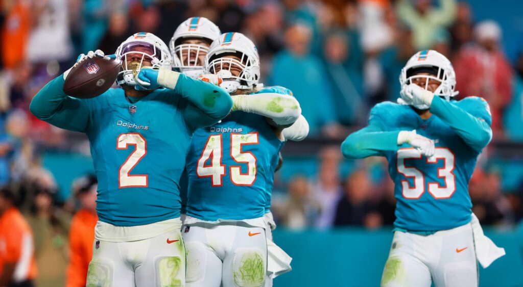 Miami Dolphins players celebrating a fumble recovery.