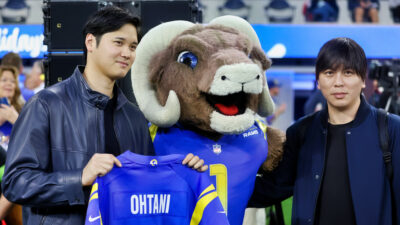 Shohei Ohtani holding up a Rams jersey with his name on the back