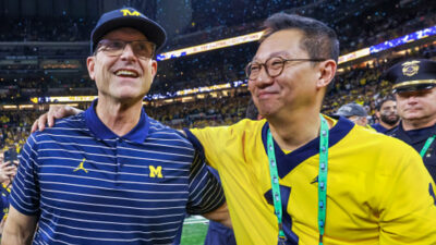 Santa Ono and Jim Harbaugh holding each other