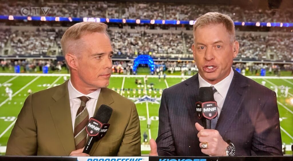 Joe Buck (left) and Troy Aikman (right) talking in booth,