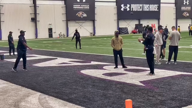 Lamar Jackson holding football during Baltimore Ravens practice.