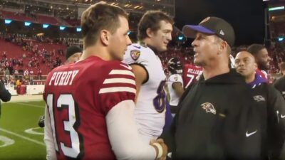 John Harbaugh and Brock Purdy shaking hands