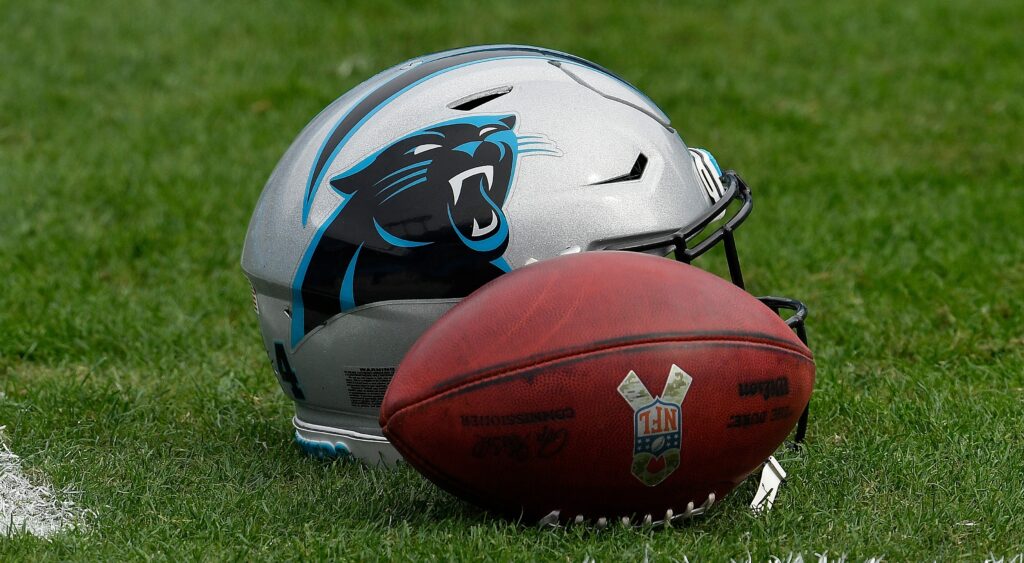 Carolina Panthers helmet and football shown on field.