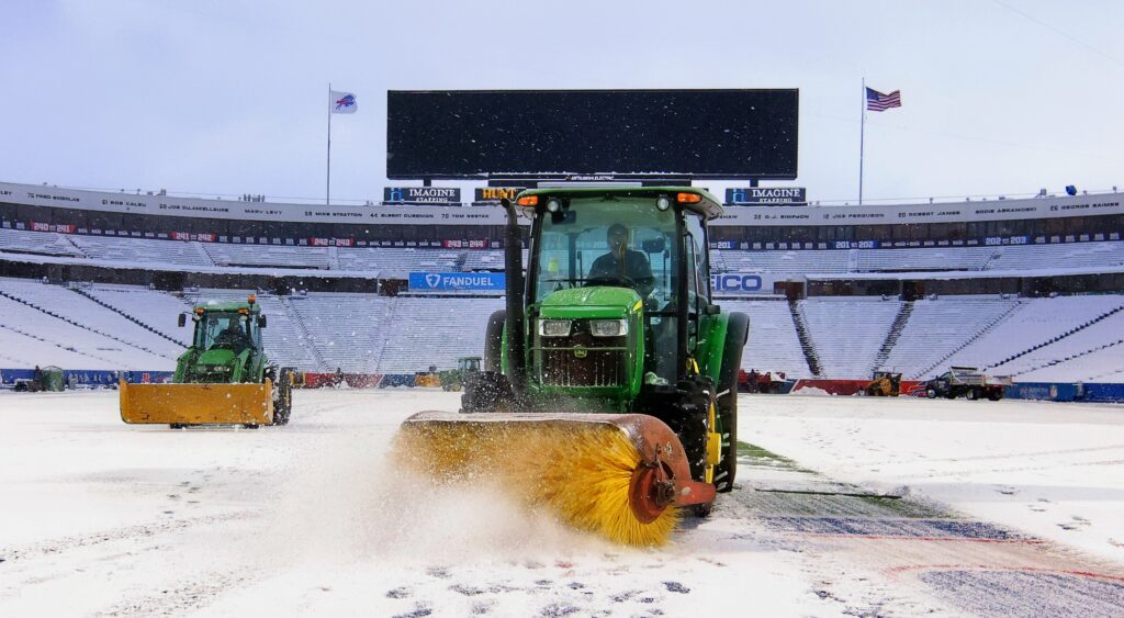 Stadium workers clearing off snow at Highmark Stadium.