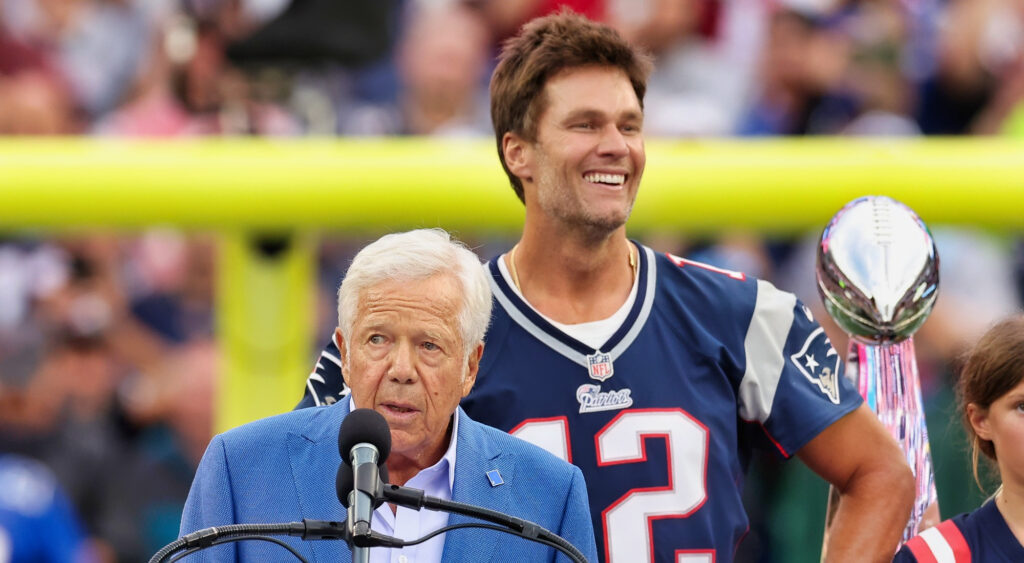 Tom Brady standing behind Robert Kraft