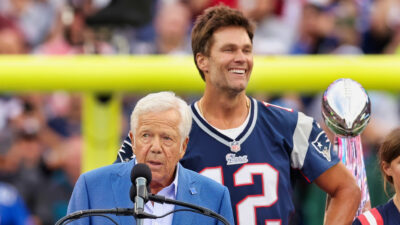 Tom Brady standing behind Robert Kraft