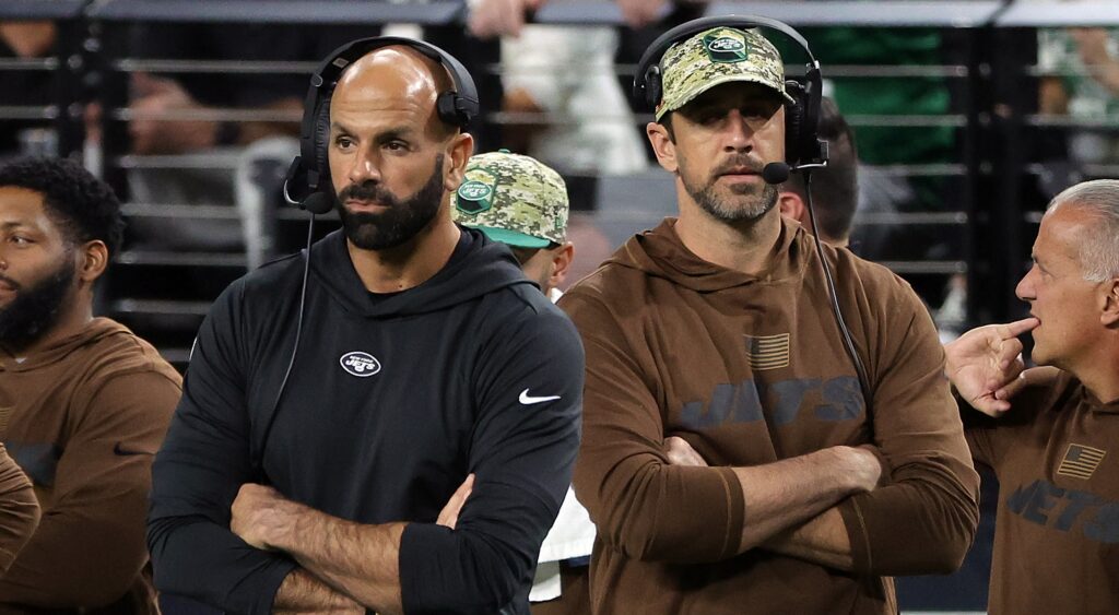 Robert Saleh and Aaron Rodgers standing with arms folded on sidelines