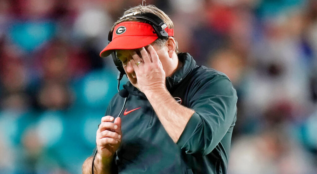 Kirby Smart with a hand on his face