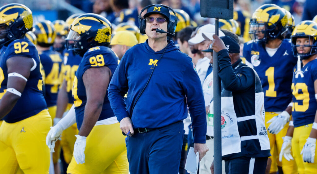 Jim Harbaugh standing in front of Michigan players