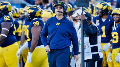 Jim Harbaugh standing in front of Michigan players