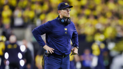 Jim Harbaugh with hands near his waist