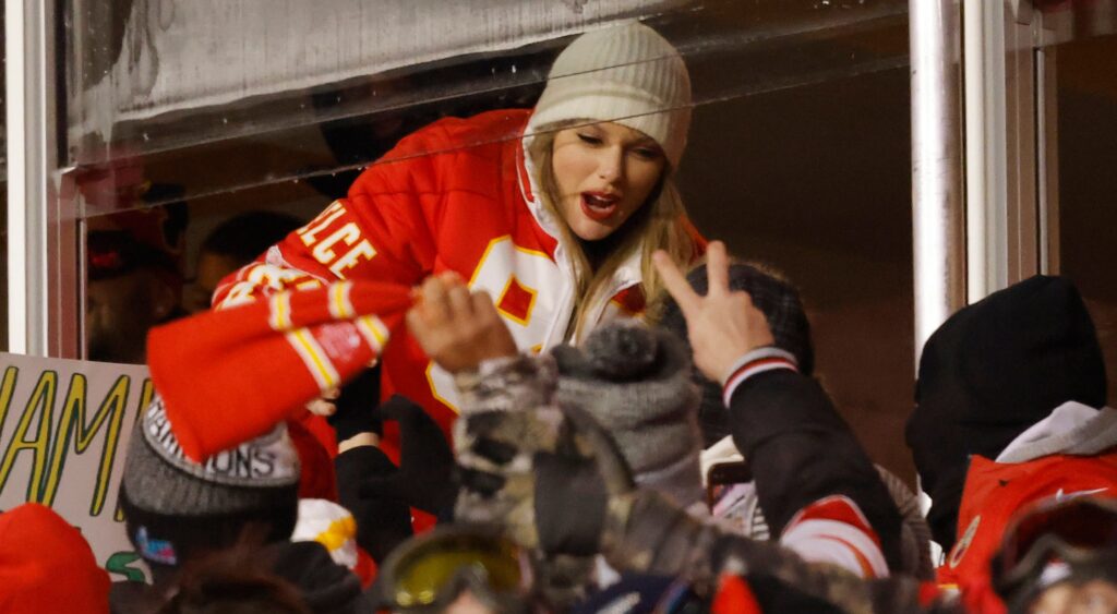 Taylor Swift hanging out of suite to greet fans