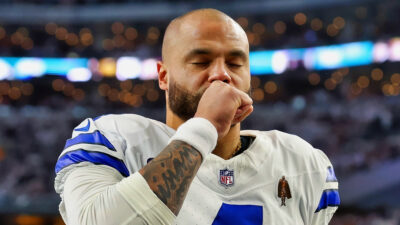Dak Prescott with his eyes closed and a hand over his mouth