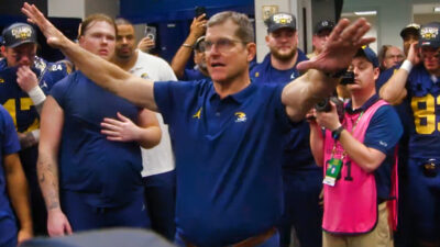 Jim Harbaugh with his hands outstretched