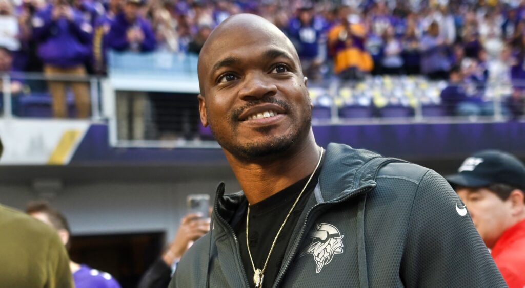Adrian Peterson looking on from field.