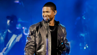 Usher performing on stage wearing black jacket