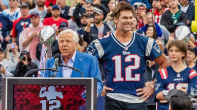 Robert Kraft speaking while standing next to Tom Brady