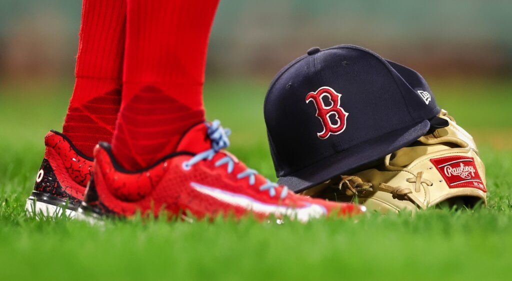 Boston Red Sox cap, glove and player standing next to it