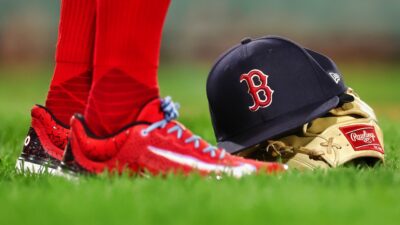 Boston Red Sox cap, glove and player standing next to it