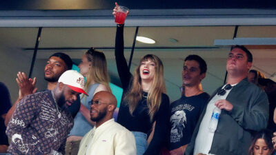 Taylor Swift holding a cup in the air