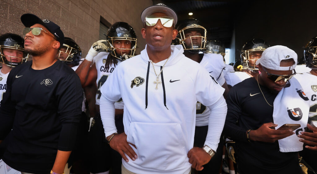 Deion Sanders standing in front of his Buffaloes team