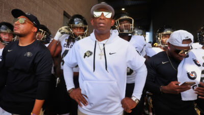 Deion Sanders standing in front of his Buffaloes team