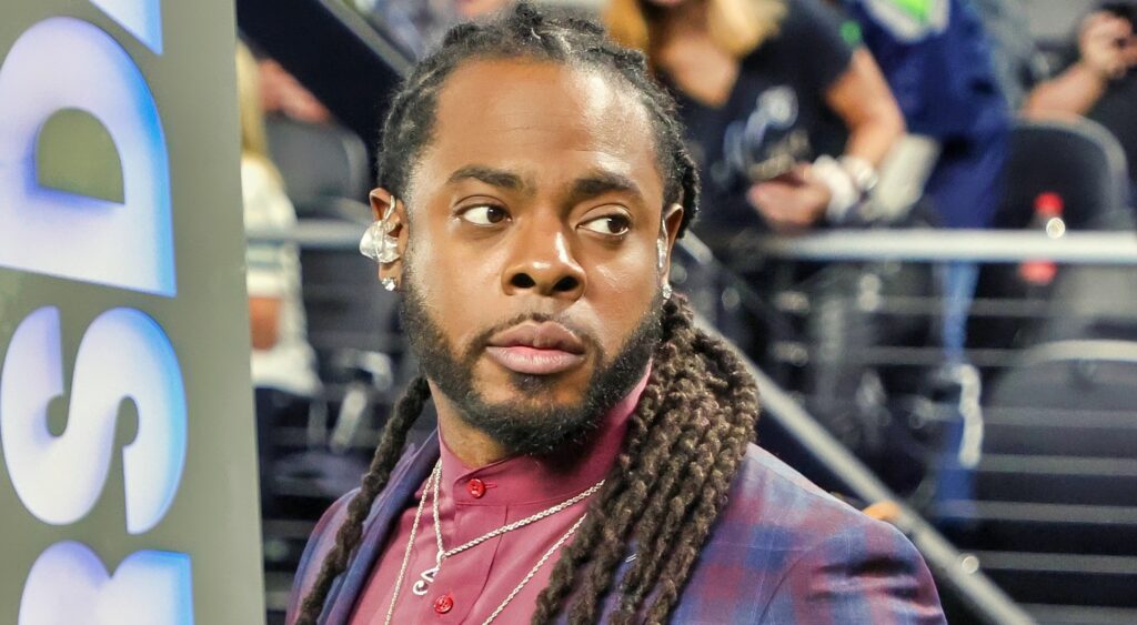 Richard Sherman looks on in his suit.
