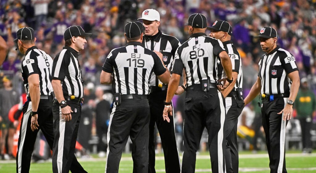 NFL referees talking during game.