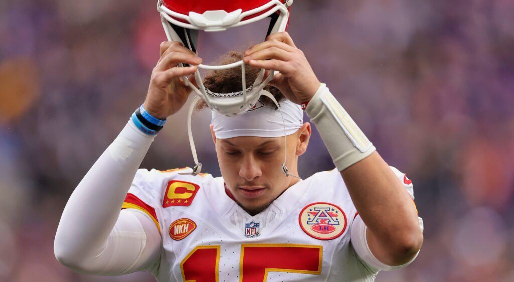 Patrick Mahomes takes off his helmet in frustration.