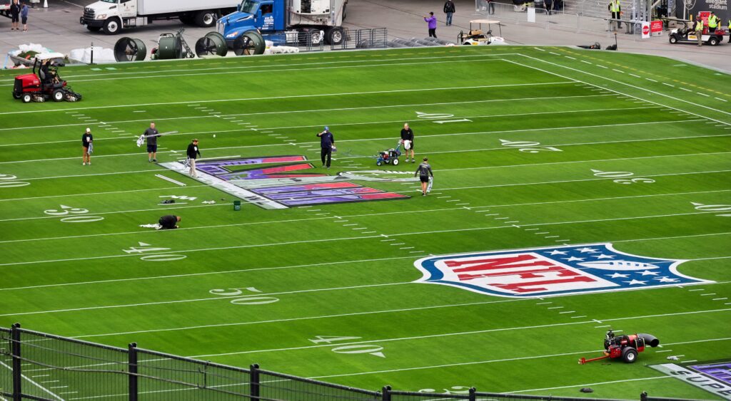 Workers prepare the field for Super Bowl 58.