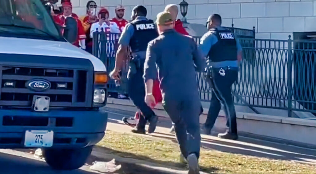 Shooter being escorted by police after Super Bowl victory parade i Kansas City