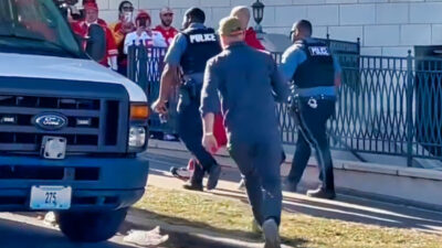 Shooter being escorted by police after Super Bowl victory parade i Kansas City