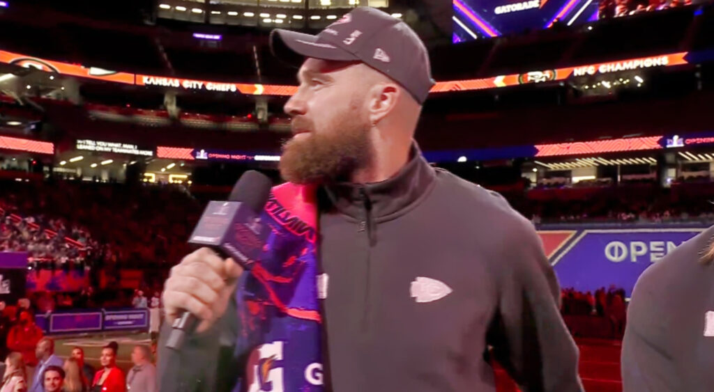 Travis Kelce holding a microphone
