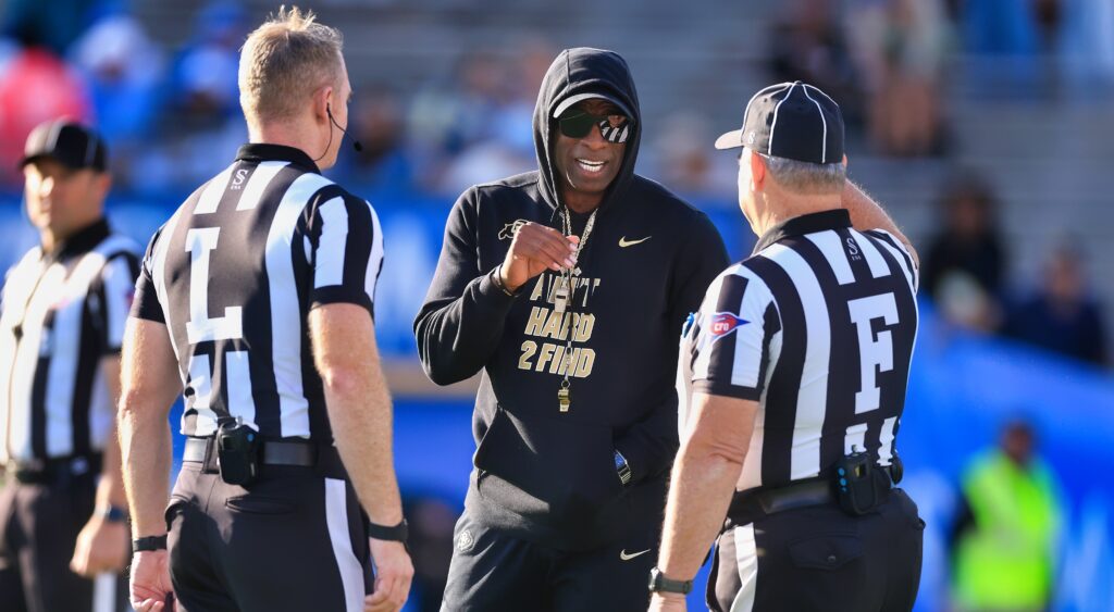 Deion Sanders speaks with refs during a game.