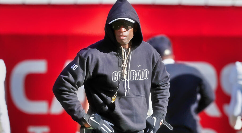 Deion Sanders with his hands on his waist