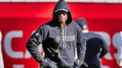Deion Sanders with his hands on his waist